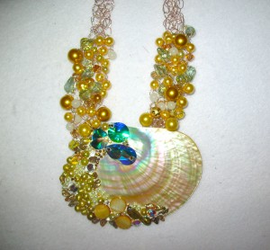 Diana Harwood used Swarovski Crystals and Crystal Clay to embellish this shell, which is on a crocheted wire necklace.